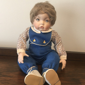 seated 17-inch Modern doll Aaron with ash blond wig and blue overalls