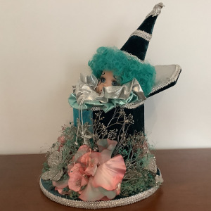 Clown doll head peeking out of music box with an assortment of party accessories