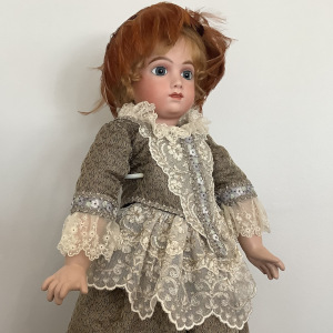 Reproduction AT doll in green and white silk dress with extensive lace trim and feathered fascinator hat, front view