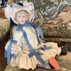 Reproduction Heubach character doll in white dress with blue ribbon