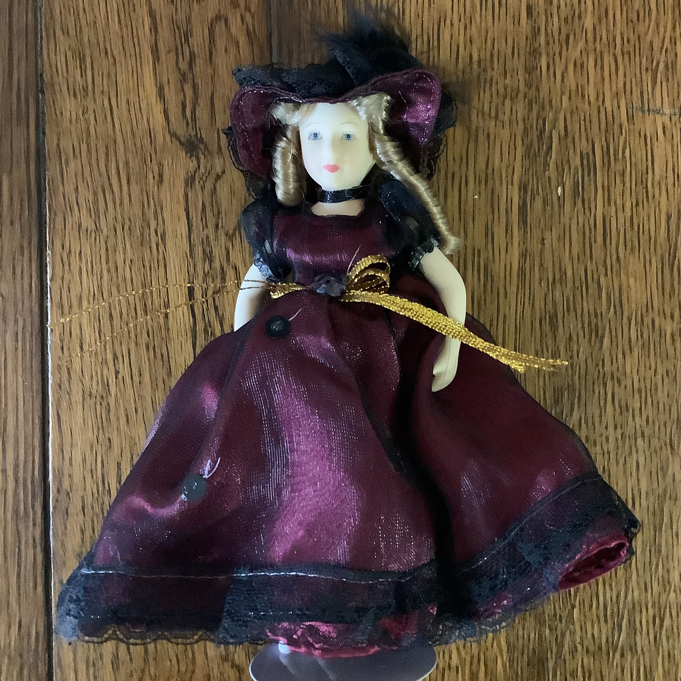 Very small 8-inch modern lady doll in purple dress and hat in synthetic fibres