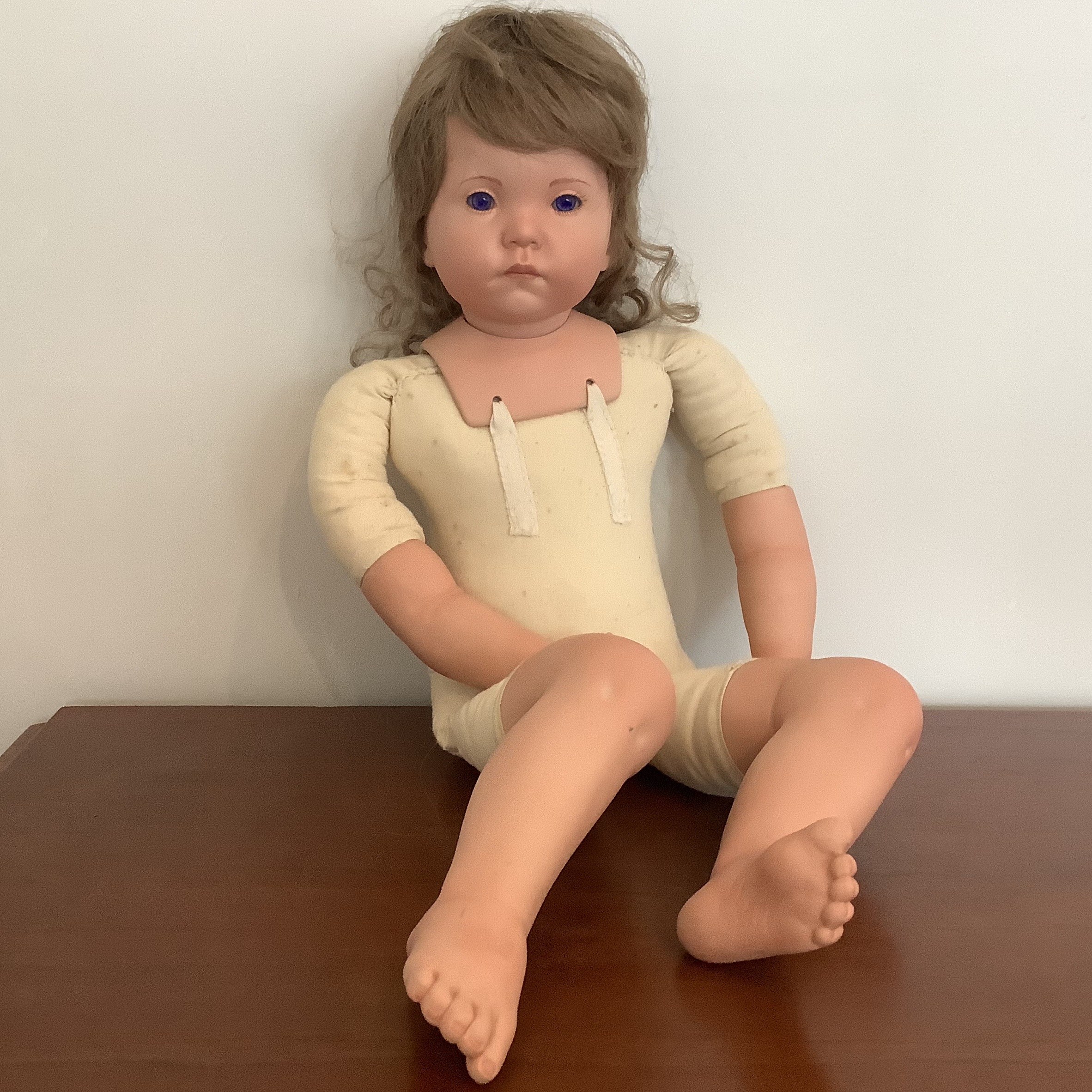 Nude light-skinned toddler doll with bent knees, glass eyes and ash-blond hair
