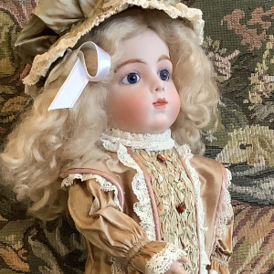 Light-skinned doll in a beige dress with extensive ruching