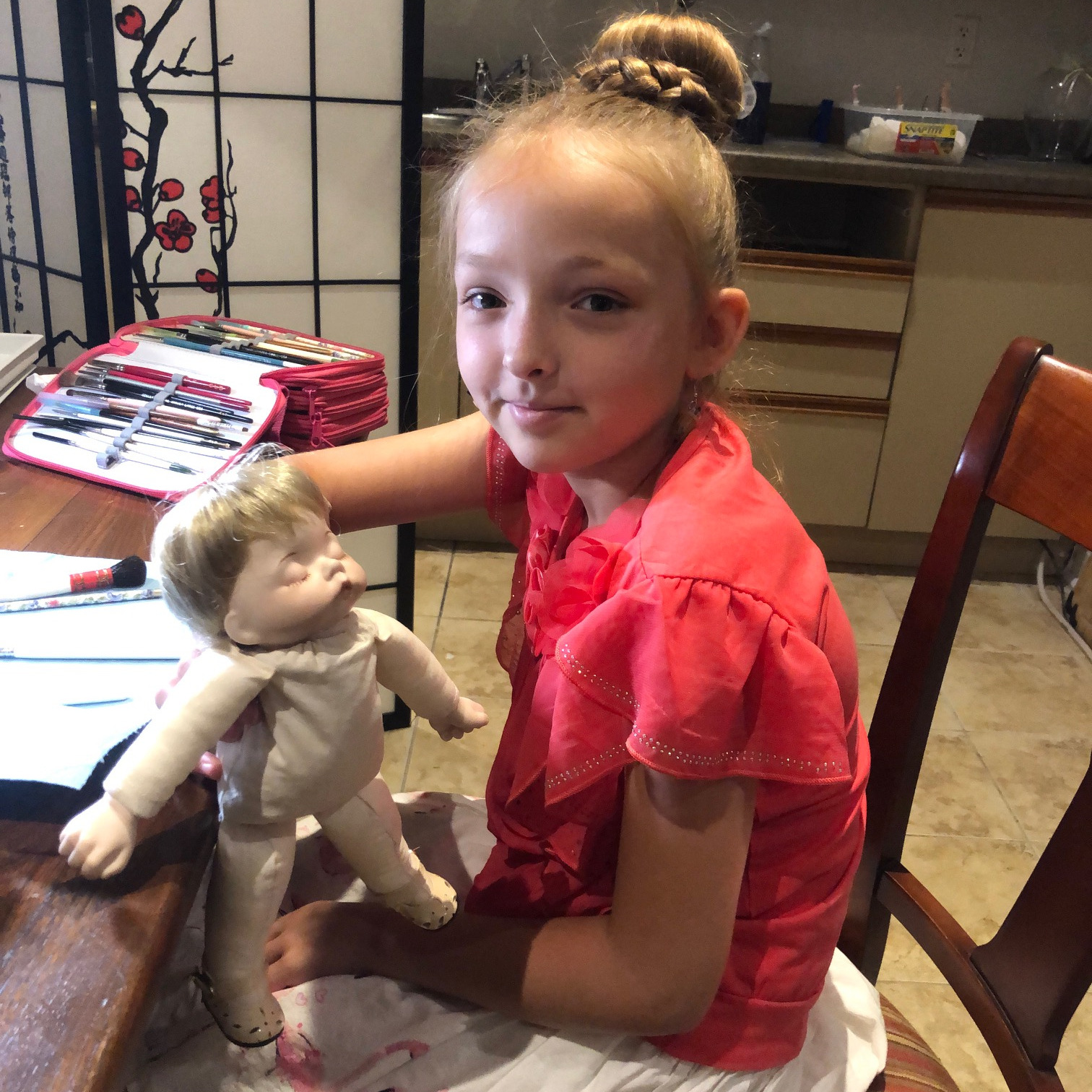 Student with doll at work table