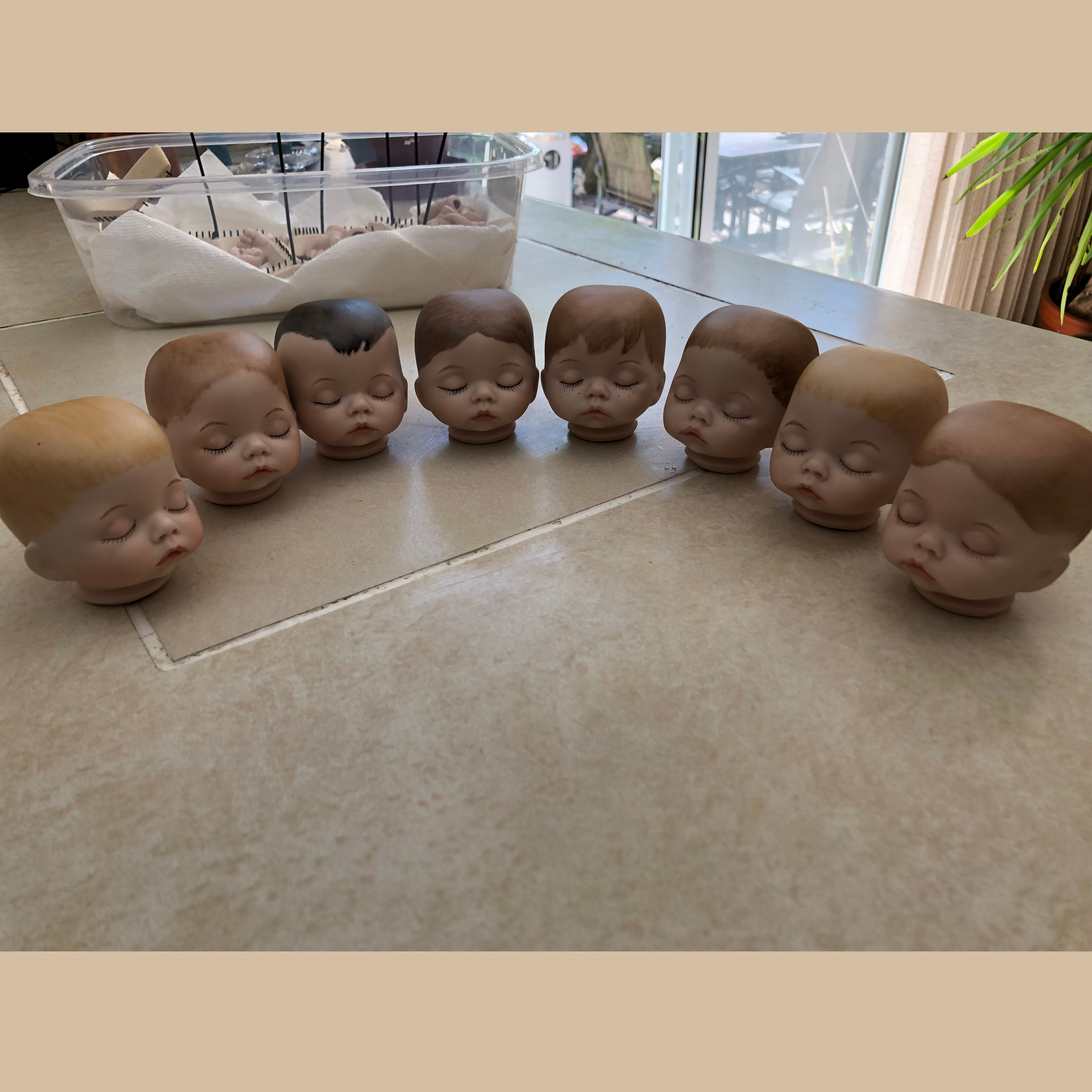 A row of painted doll heads created by students