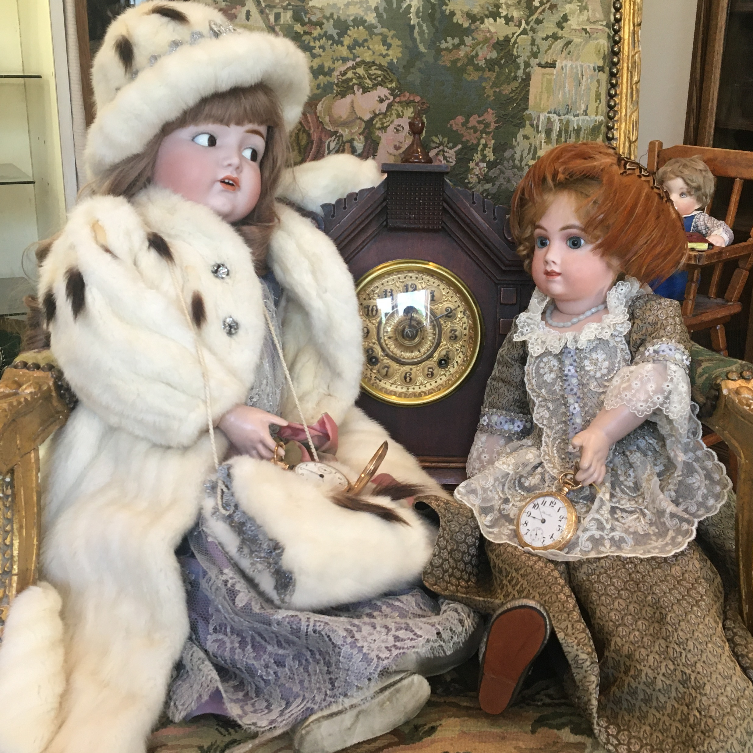 Dolls on a couch with a clock