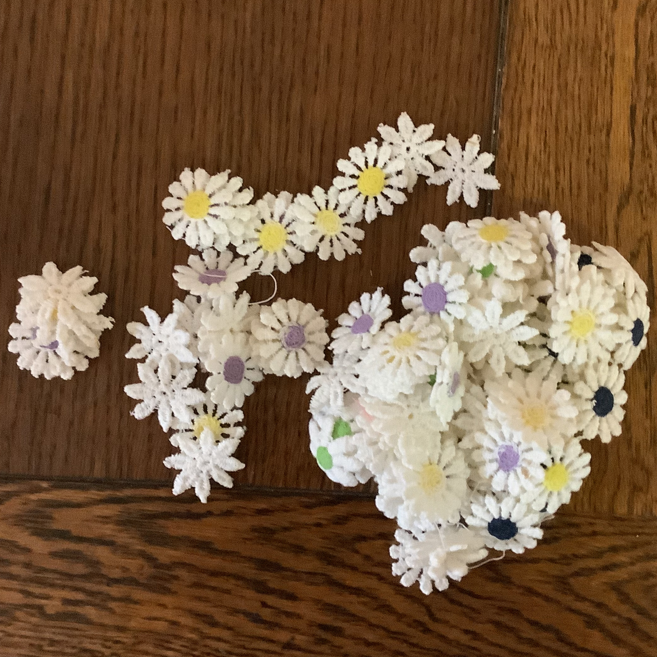 Small white applique flowers with centres in yellow, purple, green, white and navy blue