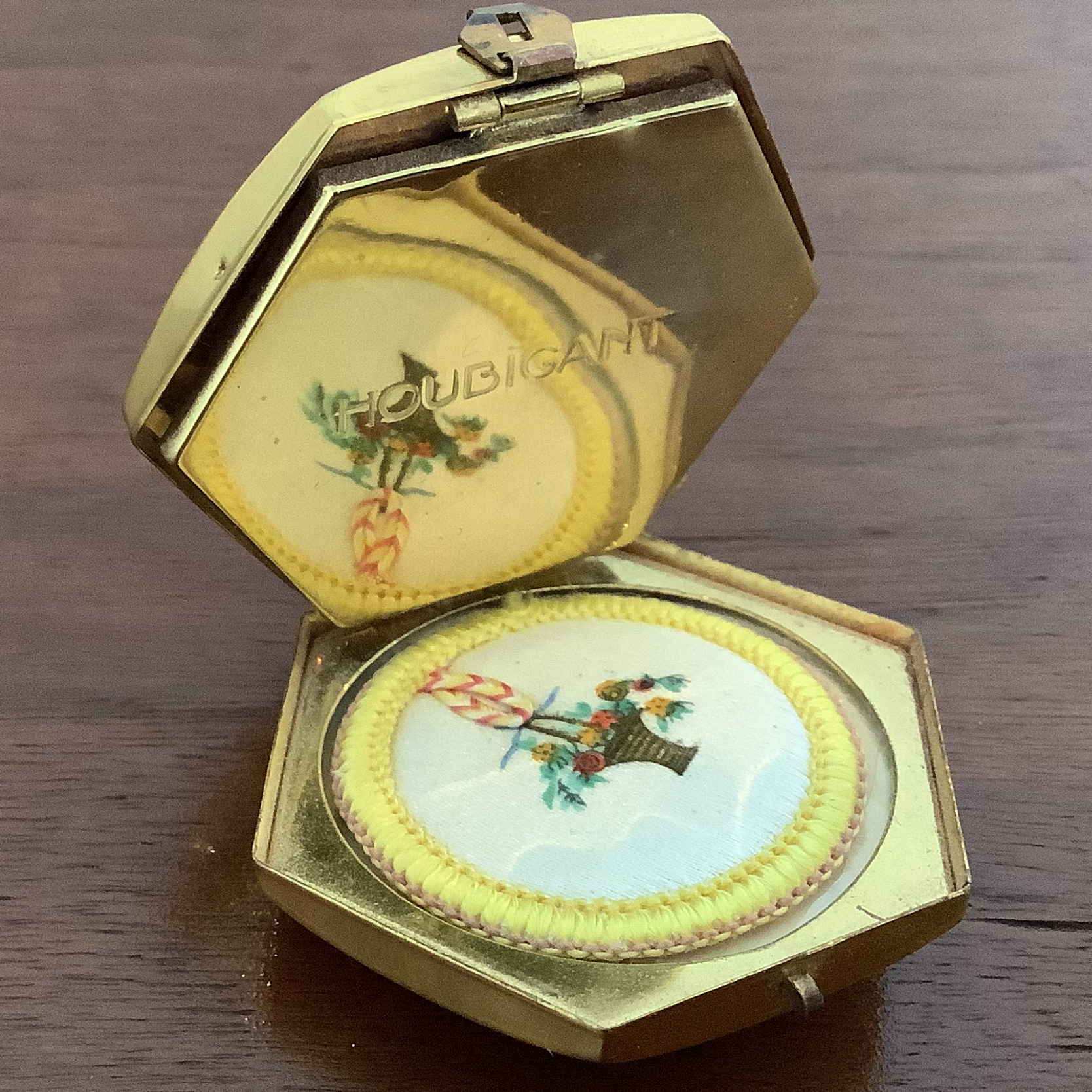 Open compact revealing one compartment covered with a powder puff