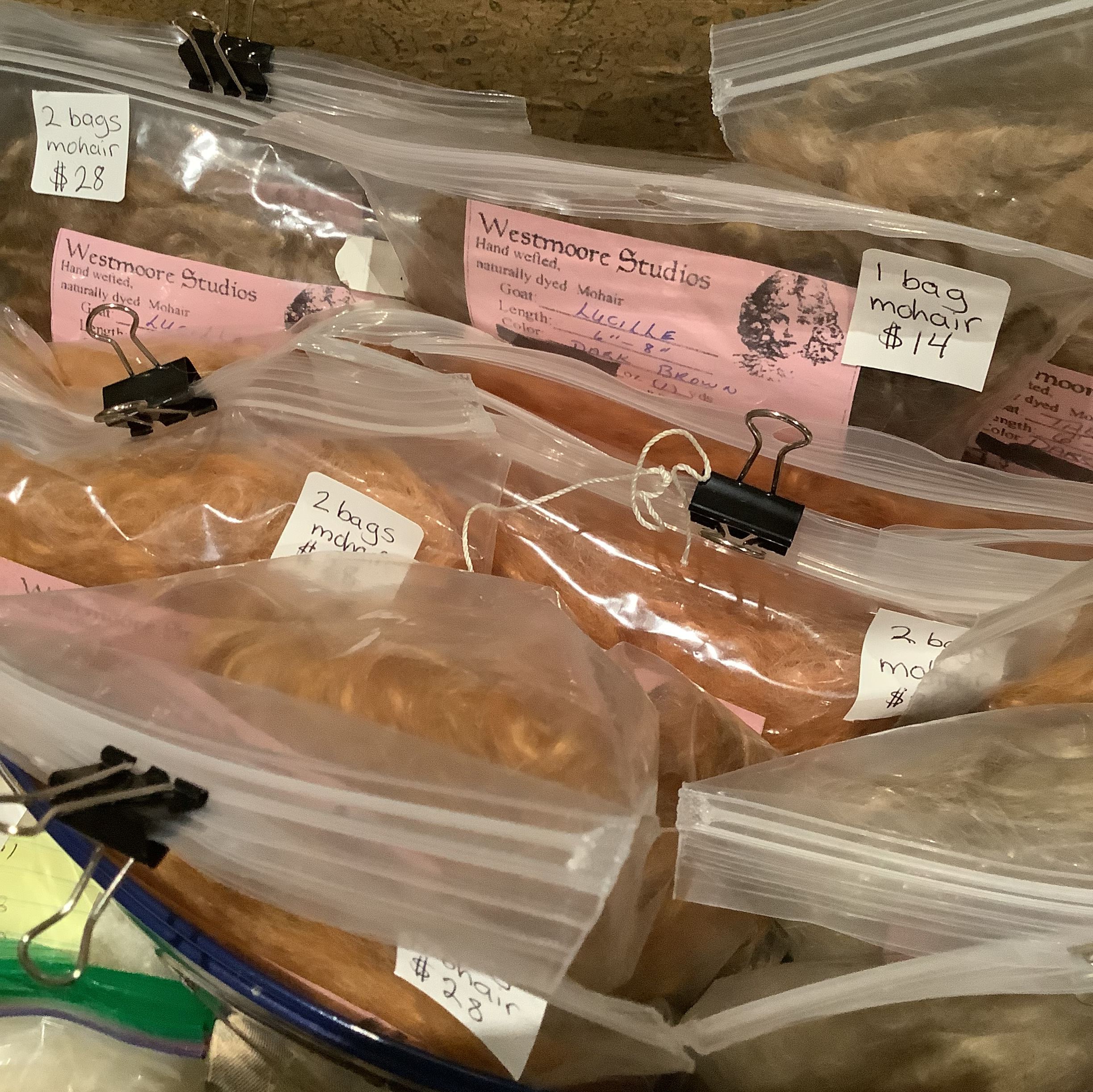 A trunk full of plastic baggies full of wefted mohair dyed in various natural shades.