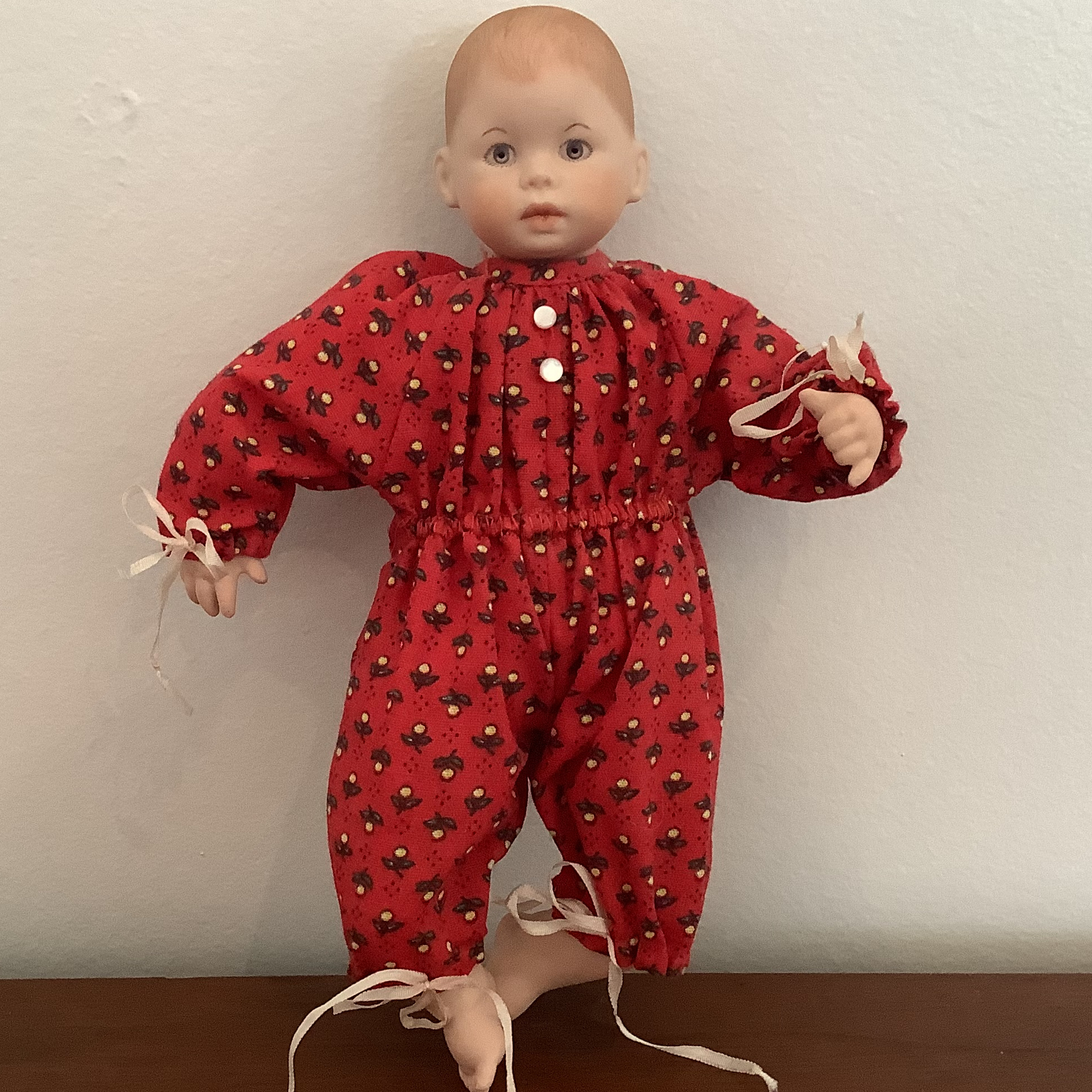 8-inch modern baby doll with painted hair and blue eyes, in a red onesie